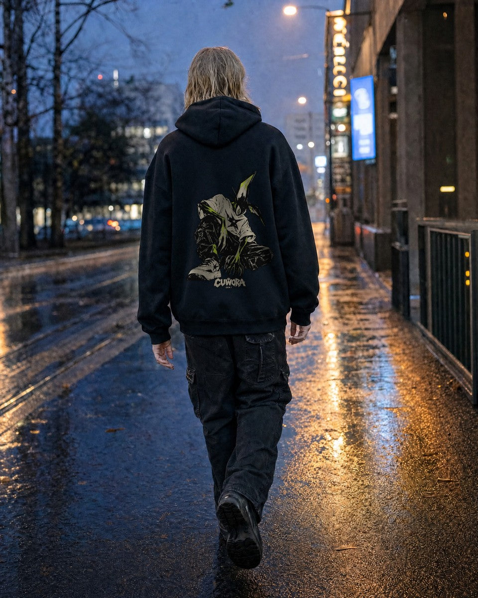 Signal Creature Hoodie in Black worn on a wet city street at dusk, back print visible